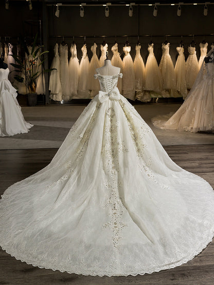 Lindo Vestido de Baile com Cauda de Capela e Ombros de Fora Vestidos de Noiva com Laço e Apliques de Miçangas